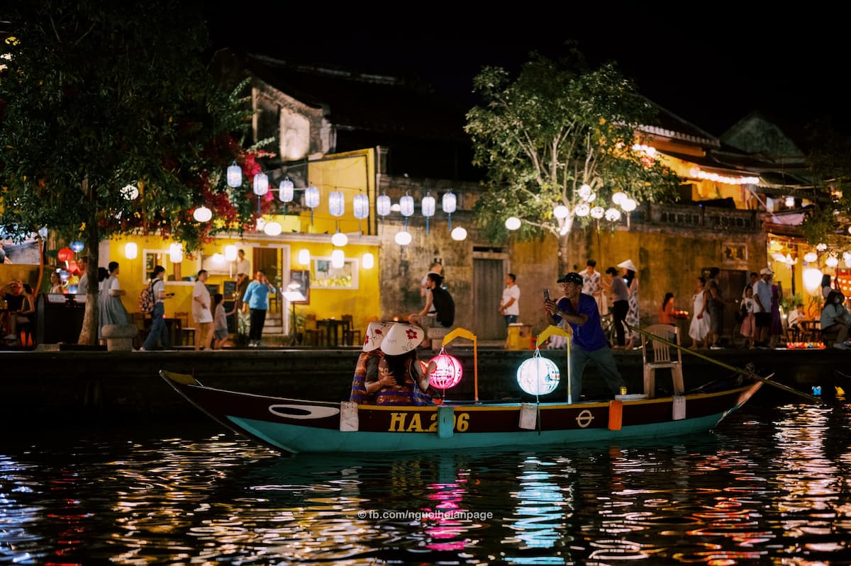 tourist taking lantern boat ride on hoai river